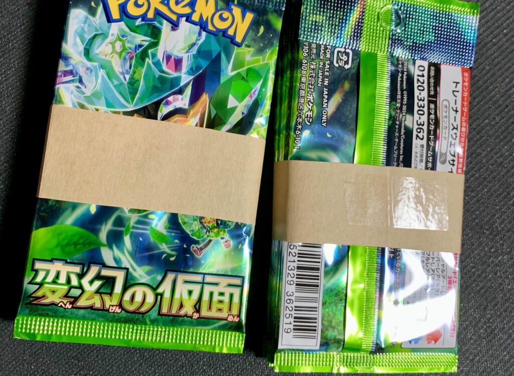 カードパックを梱包する際に封筒を帯状にしてセロハンテープでまとめている様子